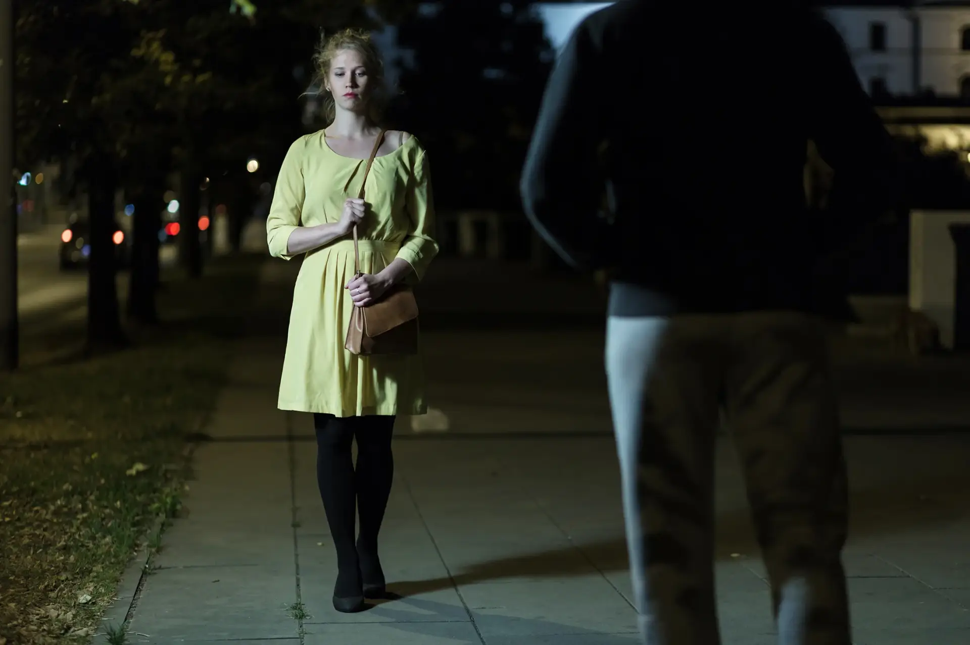 Illustration représentant une femme seule dans la rue le soir, confrontée à une personne, symbolisant une situation d'insécurité.